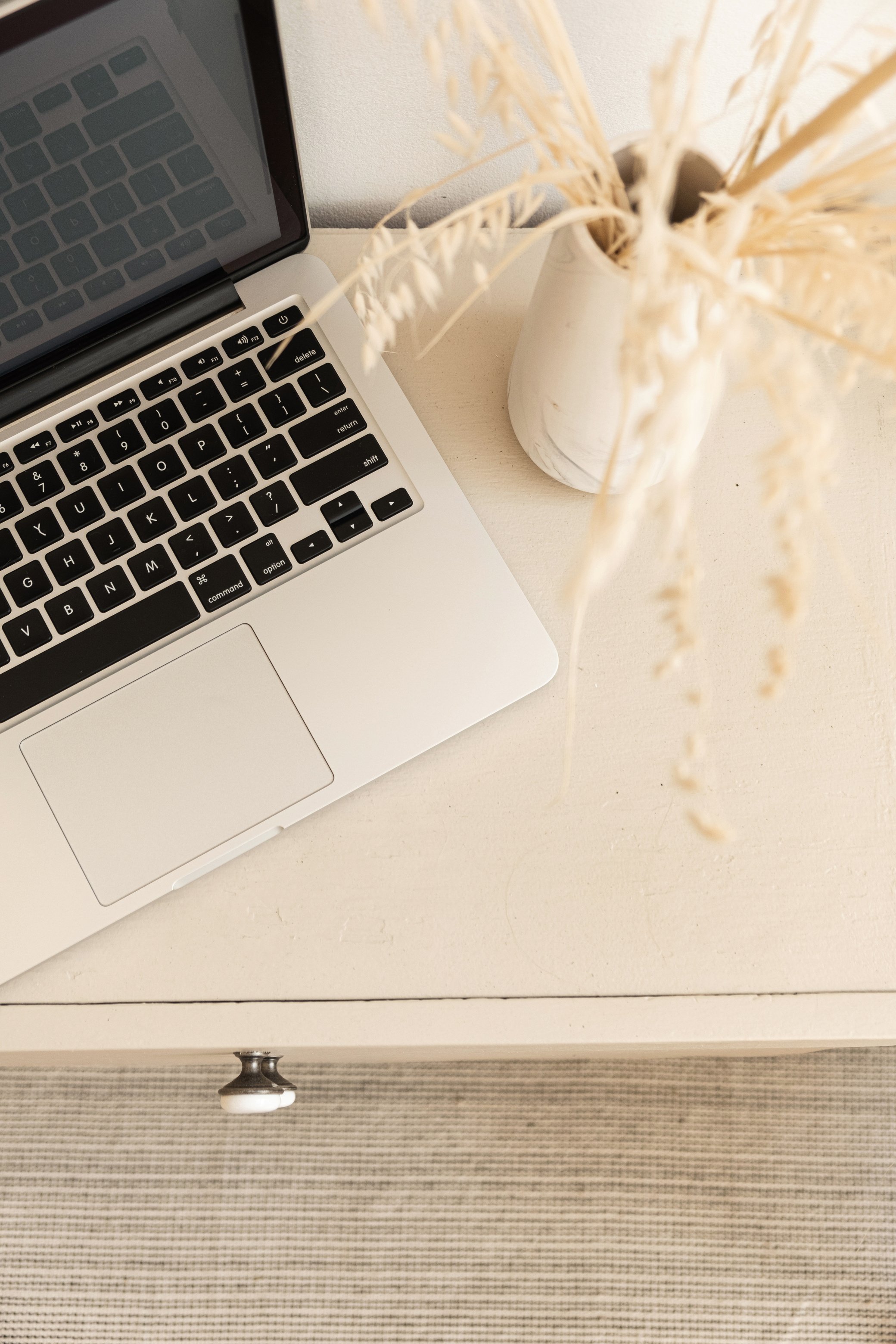 Flat Lay of Laptop with Dried Flowers on Table