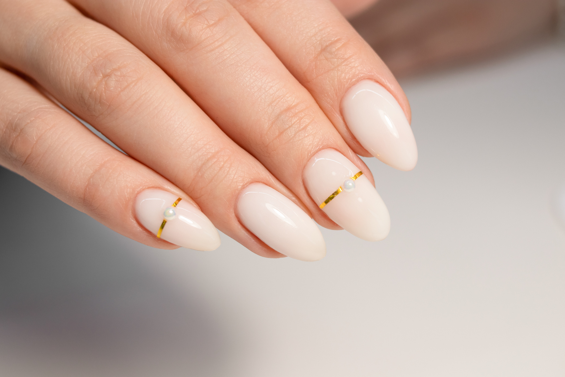 Nude manicure. Gel polish on milky nails. Almond shaped nails. Gold design nails. Beautiful manicure.